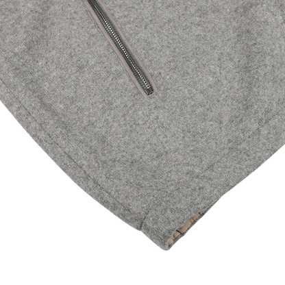 Close-up of a soft, textured gray fabric with a zipper, likely part of the sophisticated Grey Beige Cashmere Nylon Reversible Gilet by Manto.