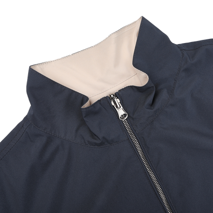 Close-up of Manto's Navy Beige Reversible Nylon Blouson, showcasing a navy exterior and light beige inner lining. It features a silver full-length zipper, standing collar, and is crafted from water-resistant nylon.