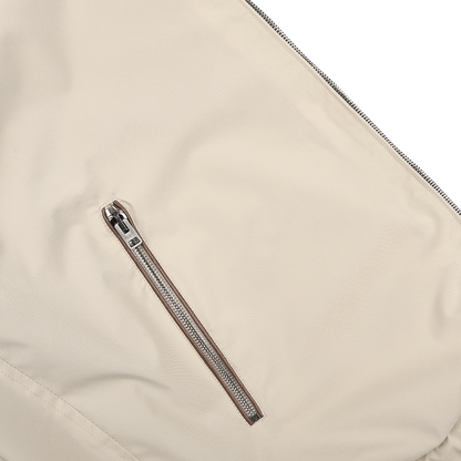 Close-up of Manto's water-resistant Navy Beige Reversible Nylon Blouson featuring a diagonal zipper pocket, showcasing its sleek design.