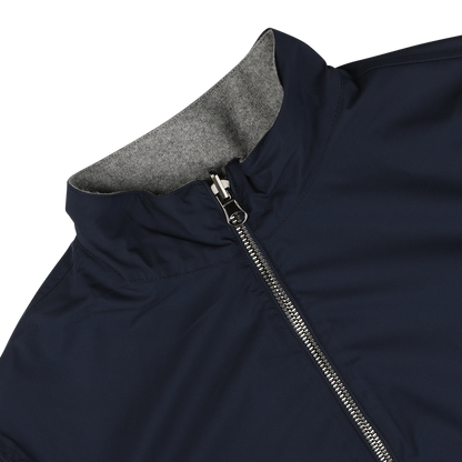 Close-up view of the Navy Grey Cashmere Nylon Reversible Blouson by Manto, featuring a dark blue exterior, a full front zipper, and a high collar that reveals its grey lining inside.