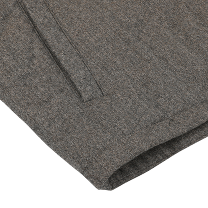 Close-up of the Maurizio Baldassari Taupe Beige Herringbone Quilted Virgin Wool Overshirt showcasing the intricate details of the fabric texture and stitching, with a visible edge and part of a pocket crafted from virgin wool.