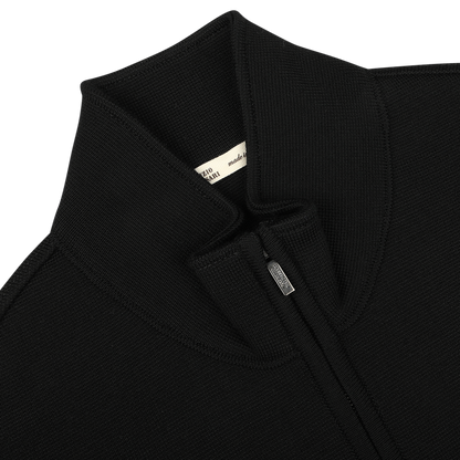 Close-up of the Black Milano Stitch Wool Zip Gilet by Maurizio Baldassari, featuring a high collar, a small manufacturer label near the collar, and crafted from virgin wool using Milano stitch.