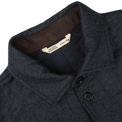 Close-up of a blue melange collared jacket with two buttons, featuring a label inside the collar that reads "Made in Italy." This Maurizio Baldassari overshirt is crafted from virgin wool and boasts sophisticated Thermore padding.