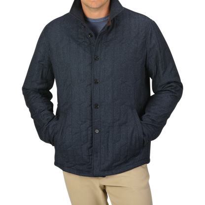 A person wearing the Blue Melange Quilted Virgin Wool Overshirt by Maurizio Baldassari with their hands in the pockets. The background is plain light gray.