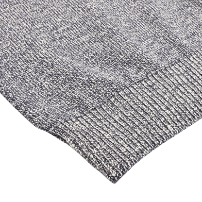 A close-up of the Blue Melange Summer Mouline Crew Neck Sweater by Maurizio Baldassari showcases its textured pattern and ribbed edge, echoing the brand's signature summer mouline knit.