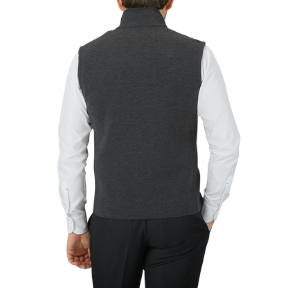 The back view of a man wearing a Maurizio Baldassari Charcoal Grey Milano Stitch Wool Zip Gilet.