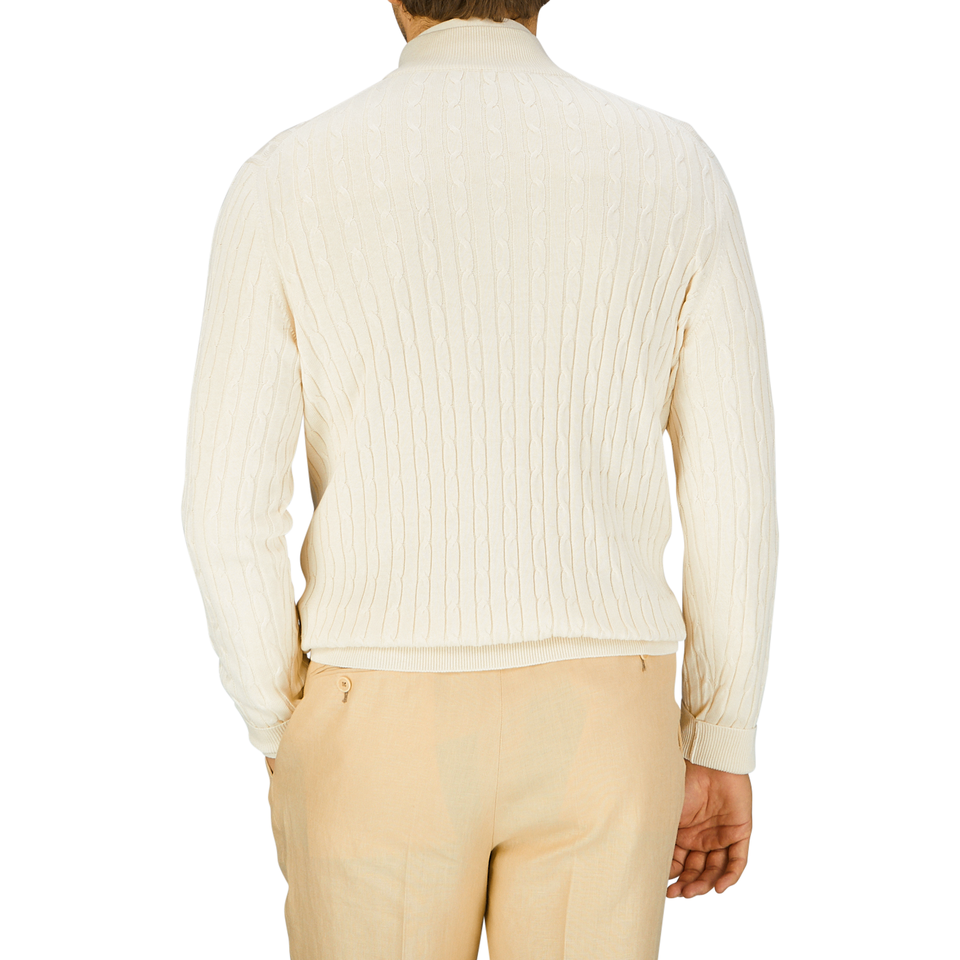 Rear view of a person wearing a Maurizio Baldassari cream cotton silk cable knit 1/4 zip sweater and light beige trousers.