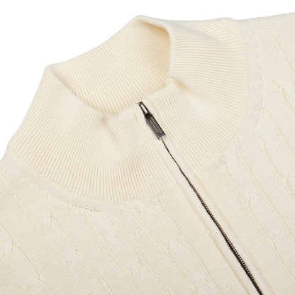Close-up view of a Maurizio Baldassari Cream Cotton Silk Cable Knit 1/4 Zip Sweater with a zipper detail at the collar.