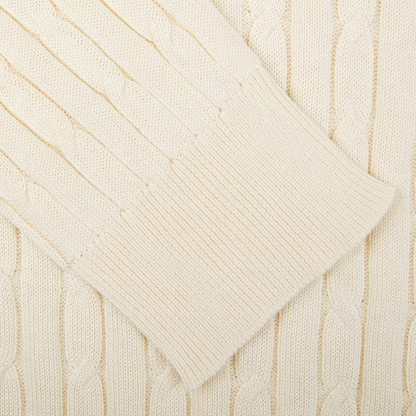 Close-up view of a Maurizio Baldassari cream-colored cotton-silk blend cable knit sweater fabric.