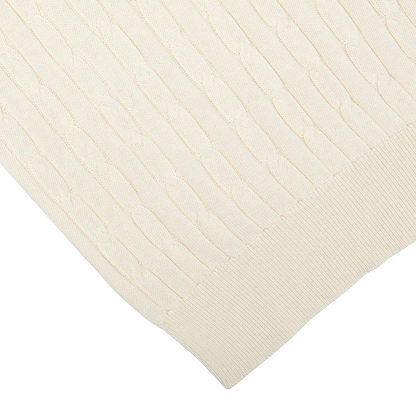 Close-up of a Cream Cotton Silk Cable Knit 1/4 Zip Sweater by Maurizio Baldassari with ribbed and wavy patterns.