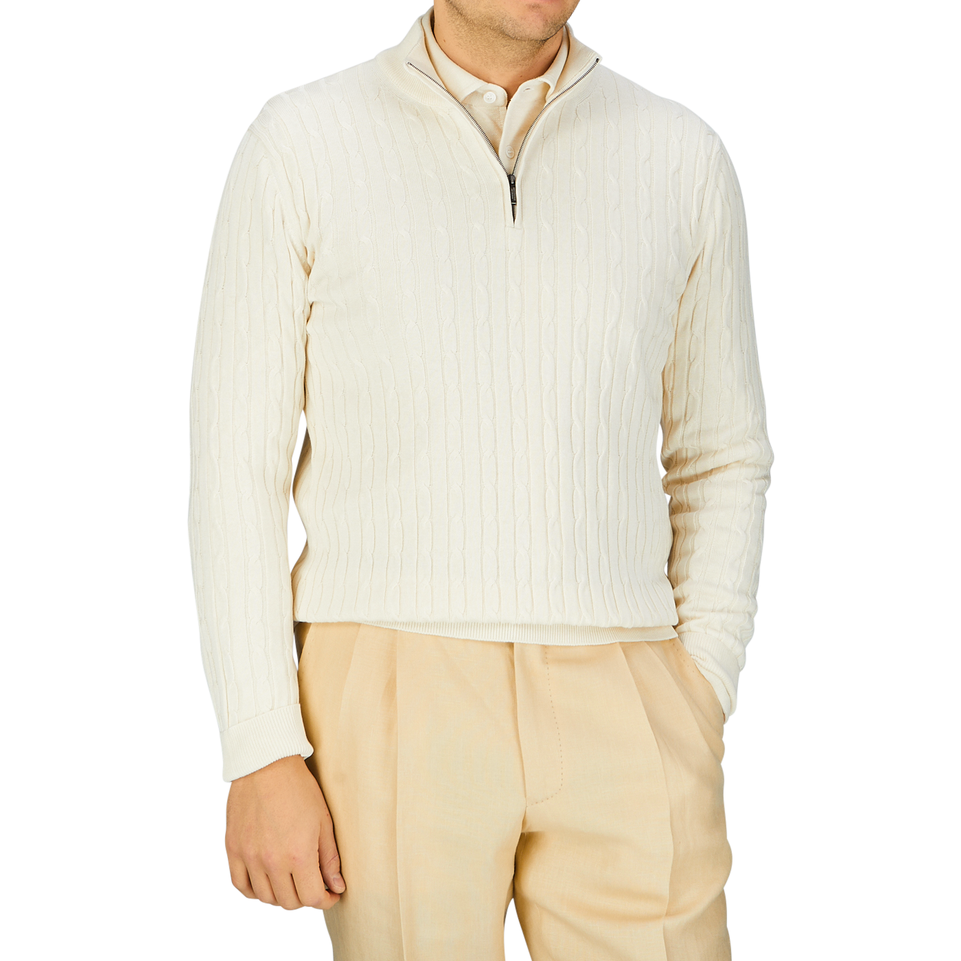 A person wearing a Cream Cotton Silk Cable Knit 1/4 Zip Sweater crafted by Maurizio Baldassari, with a zipper collar and light beige trousers.