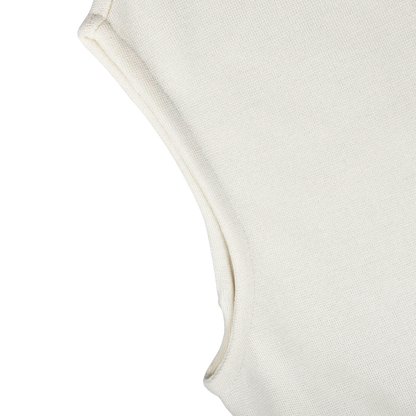 Close-up of the armhole and shoulder seam of the Cream Milano Stitch Wool Zip Gilet by Maurizio Baldassari, a sleeveless off-white textured fabric garment crafted using Milano stitch techniques, against a light gray background.