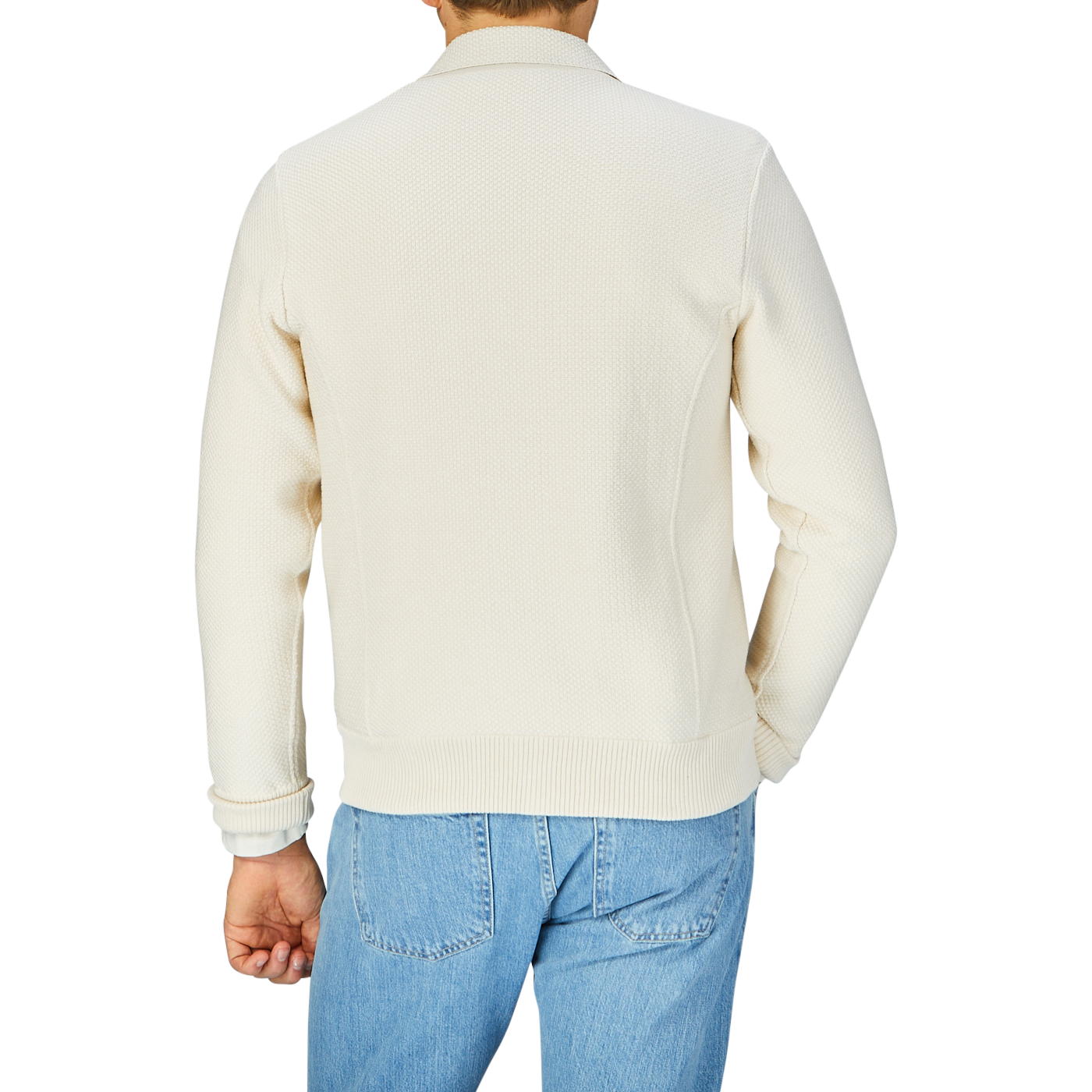 Rear view of a person wearing a Maurizio Baldassari Cream Beige Silk Cotton Knitted Blouson and blue jeans.