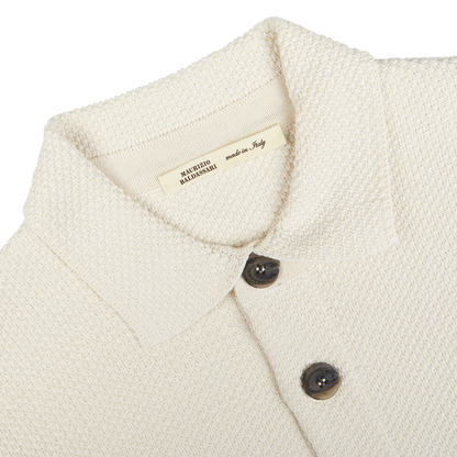 Close-up of a Cream Beige Silk Cotton Knitted Blouson collar and buttons with a label indicating "made in Italy" by Maurizio Baldassari.