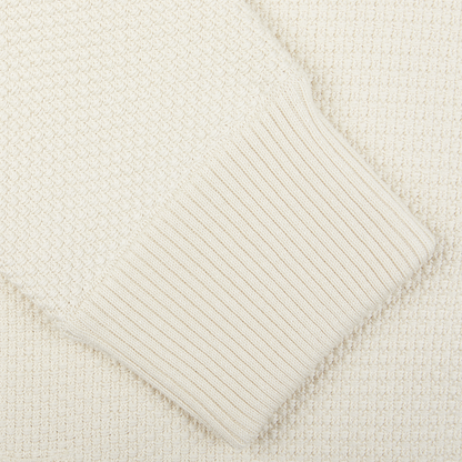 Close-up of a cream-colored Maurizio Baldassari Cream Beige Silk Cotton Knitted Blouson sweater with ribbed cuff detail.