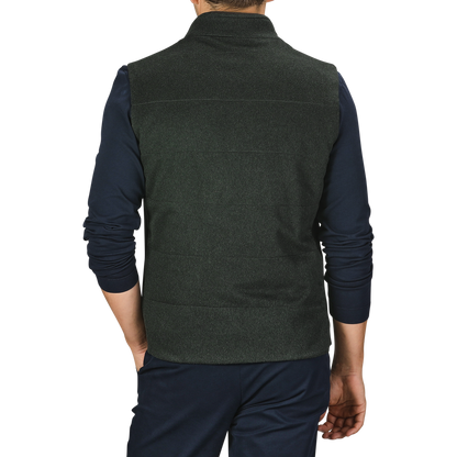 A person is shown from the back, wearing a Dark Green Water Repellent Cashmere Gilet by Maurizio Baldassari and a long-sleeved navy blue shirt with dark pants. The background is plain grey.
