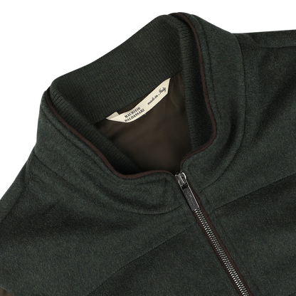 Close-up of a dark green water-repellent cashmere gilet with a ribbed collar, labeled "Maurizio Baldassari" inside, made from 100% cashmere.