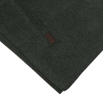 Close-up of the Dark Green Water Repellent Cashmere Gilet by Maurizio Baldassari, featuring a zipper and a small brown tag.