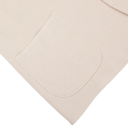 Beige silk-cotton blend fabric with a pocket detail on a white background. 
Product Name: Light Beige Silk Cotton Knitted Milano Blazer
Brand Name: Maurizio Baldassari