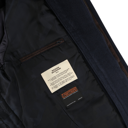 Close-up of the interior lining of the Navy Cashmere Half Padded Chore Coat by Maurizio Baldassari, featuring a zippered pocket and labels for machine wash instructions and Thermore insulation material.