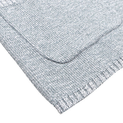 Close-up of light gray textured fabric featuring a woven pattern with neat edges, exuding relaxed luxury. Made from a cotton-viscose blend, it resembles the elegance of the Sky Blue Summer Mouline Knitted Jacket by Maurizio Baldassari.