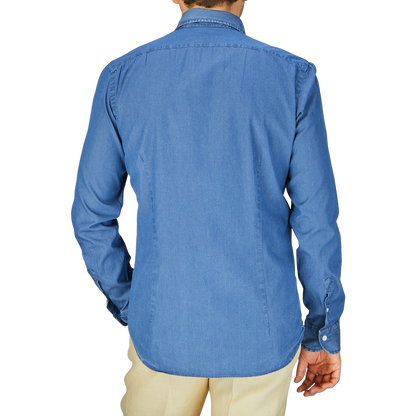 A person standing with their back to the camera, wearing a Dark Denim Washed Cotton BD Regular Fit Shirt by Mazzarelli and beige pants.