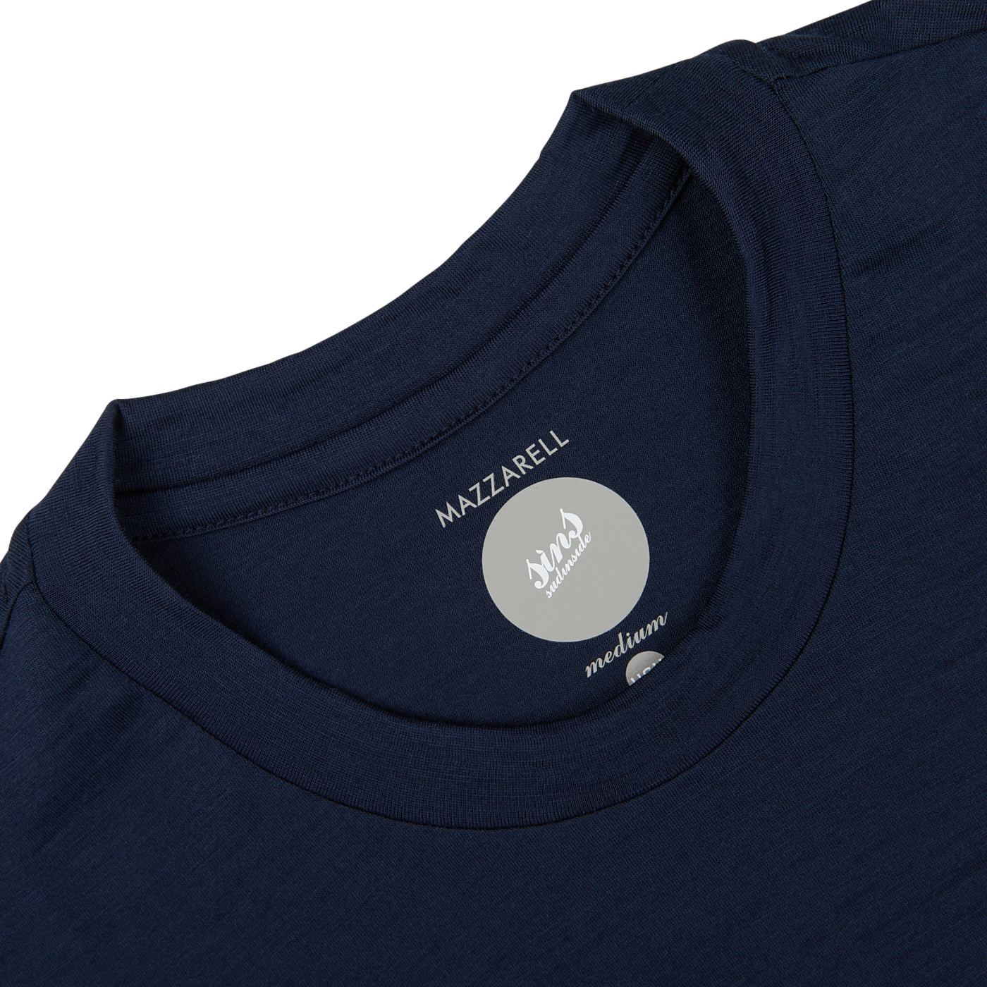 Close-up of a Navy Blue Merino Wool T-shirt's label showing the brand "Mazzarelli" in a medium, slim fit size, set against a white background.