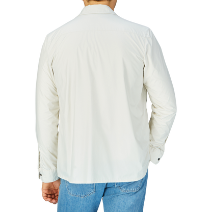 Man wearing a white shirt and blue jeans viewed from behind, covered by a slim fit Off-White Nylon Water Resistant Overshirt by Mazzarelli.