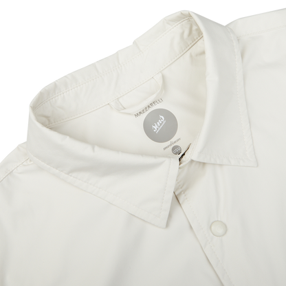 Close-up view of a beige Mazzarelli Off-White Nylon Water Resistant Overshirt collar displaying a brand label.