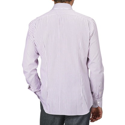 The individual is wearing a Purple Double Striped Cotton BD Regular Shirt by Mazzarelli, showcasing a long-sleeved white and purple striped design with a soft button-down collar and hand-stitched pleated shoulder, elegantly seen from the back.