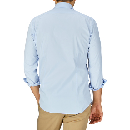 A man seen from behind wearing a Sky Blue Cotton Gabardine Regular Fit Shirt by Mazzarelli and beige pants.