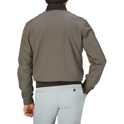 Man wearing a Moorer Olive Green Technical Nylon Blouson and light-colored pants viewed from the back.