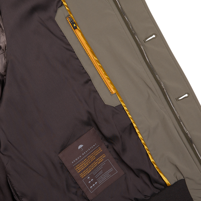 Close-up of a partially unzipped Moorer Olive Green Technical Nylon Blouson, made of wind-resistant technical nylon, with a yellow inner lining and a care label visible.