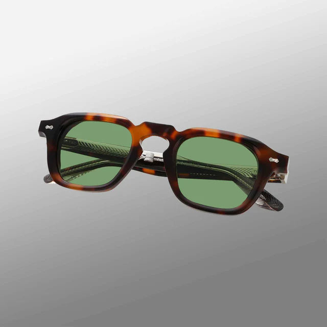The Ply Brown Havana | Green sunglasses by TBD Eyewear feature vintage-inspired brown havana acetate renew frames, handcrafted in Italy with green-tinted lenses and subtly textured arms, shown against a gray gradient background. , available at Richard Gelding Mayfair