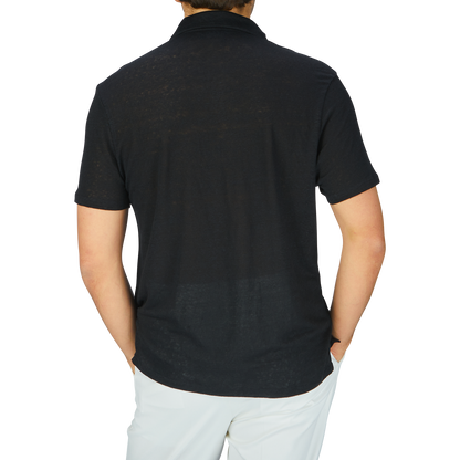 The man is wearing a Paige black linen Capri collar polo shirt, which is breathable and comfortable thanks to its linen fabric.