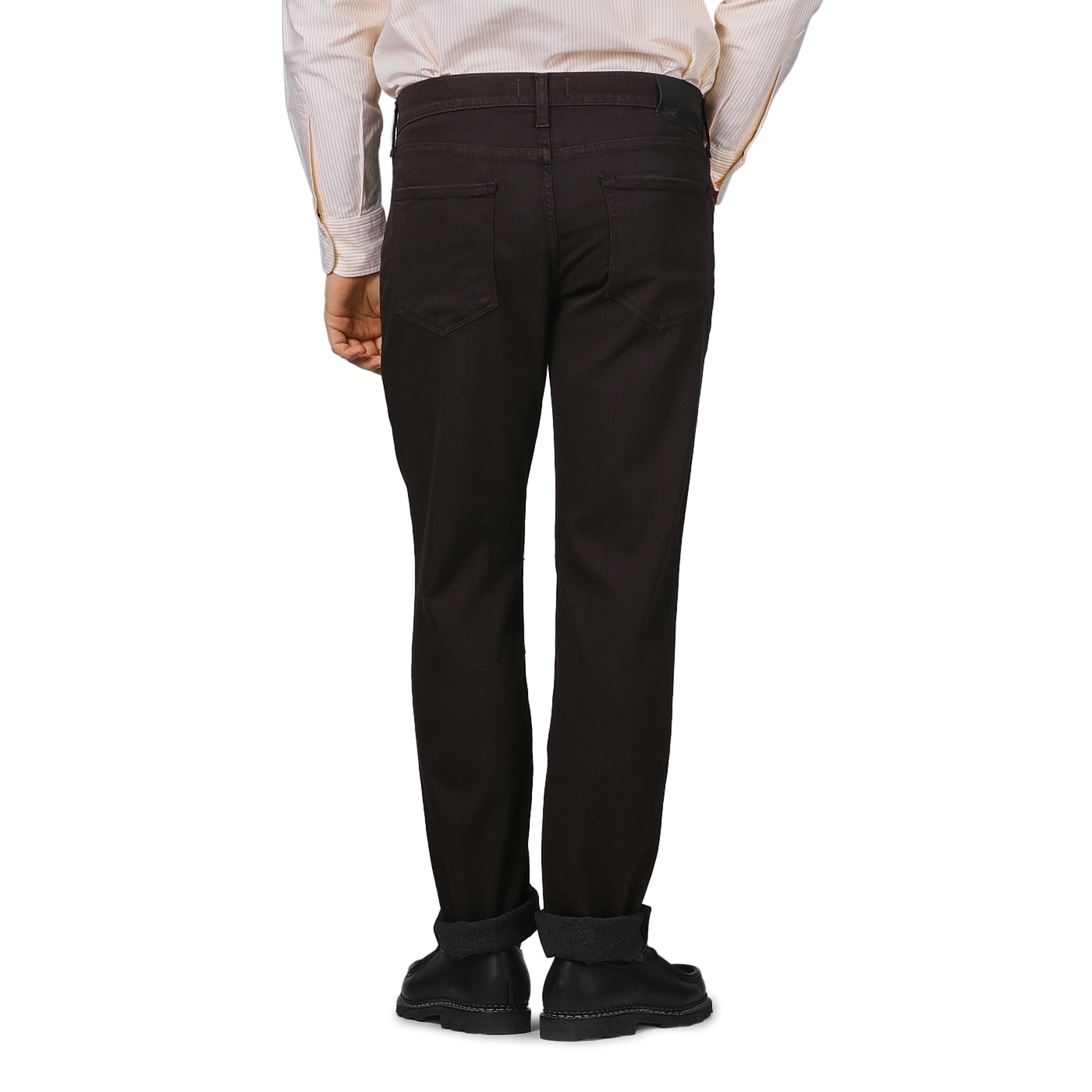 Rear view of a person wearing a striped shirt and Paige's Brown Cotton Transcend Normandie Jeans, hands by their sides against a gray background.