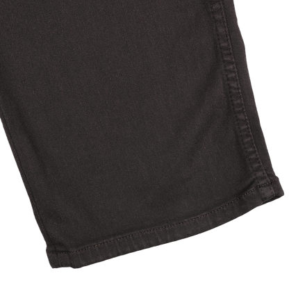 Close-up view of the hem of Paige's Brown Cotton Transcend Normandie Jeans on a white background.