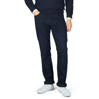 Man standing in Paige's Inkwell Blue Cotton Transcend Normandie jeans and white sneakers.