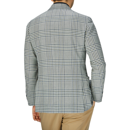 Woman from behind wearing a Ring Jacket Blue Green Glen Check Balloon Wool Blazer and beige trousers, standing against a gray background.