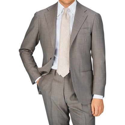 A man in a Ring Jacket Mid Grey High-Twist Wool Suit with his hand in his pocket.