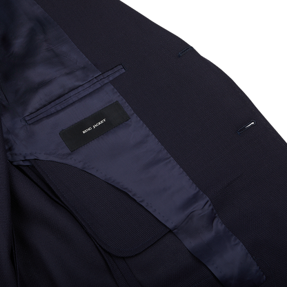 Close-up of a Navy Blue Wool Balloon Travel Blazer with a "Ring Jacket" brand label visible inside.