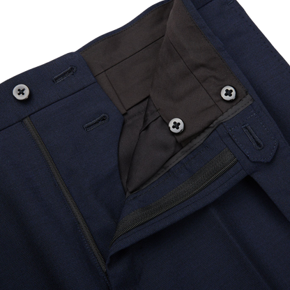 Close-up of a Ring Jacket navy blue high twist wool suit, showing the buttoned waistband and zipper, with detailed stitching and fabric texture visible.