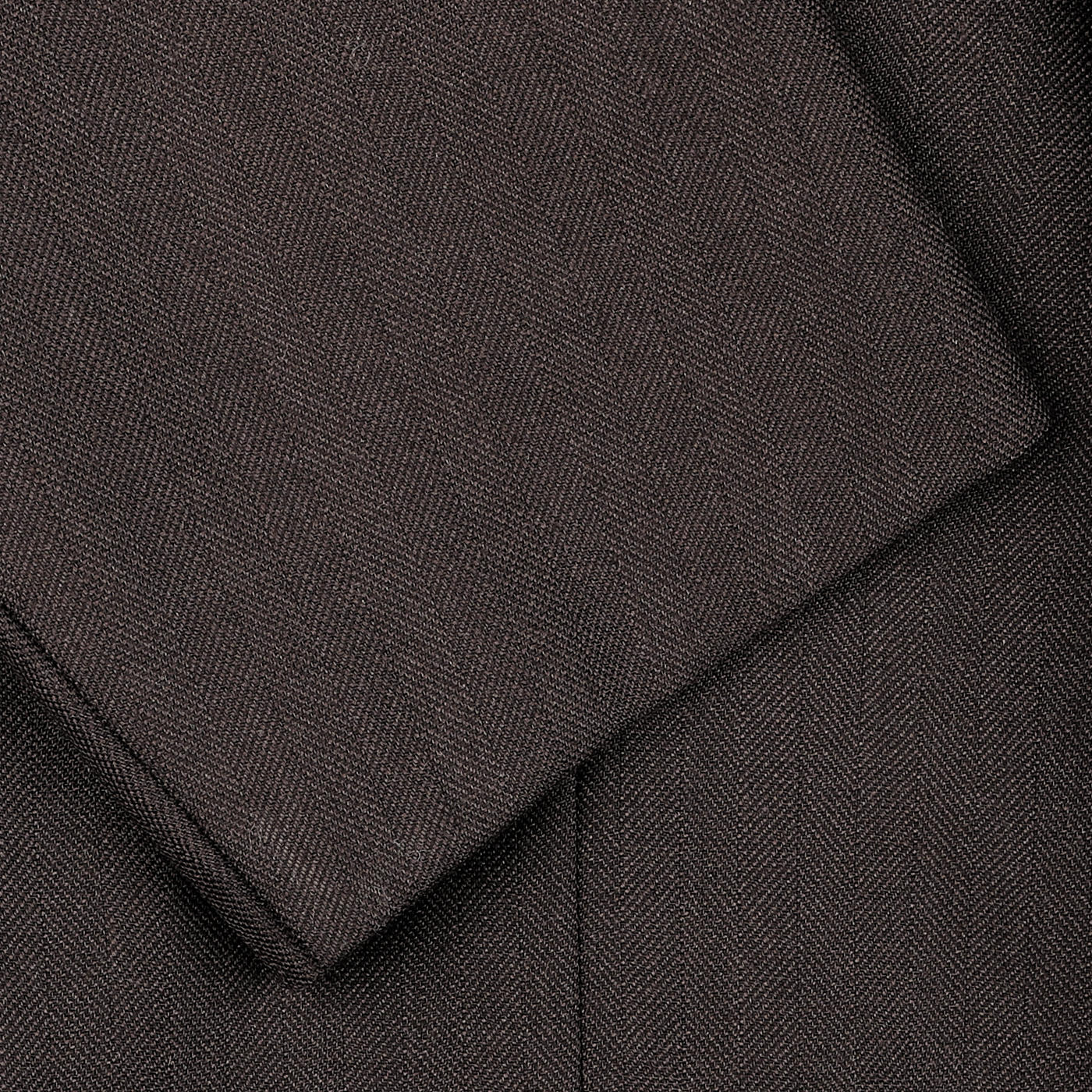 Close-up of the Brown Herringbone Calm Twist Wool Suit by Ring Jacket, showcasing its dark brown fabric with overlapping edges.