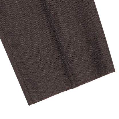 Close-up of the hem of a Brown Herringbone Calm Twist Wool Suit pant by Ring Jacket, highlighting the meticulous stitching line and the textured wool fabric.