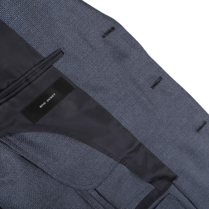 Close-up of the inside of a blue sports coat with a black label reading "Ring Jacket" and black lining, crafted from durable travel cloth.