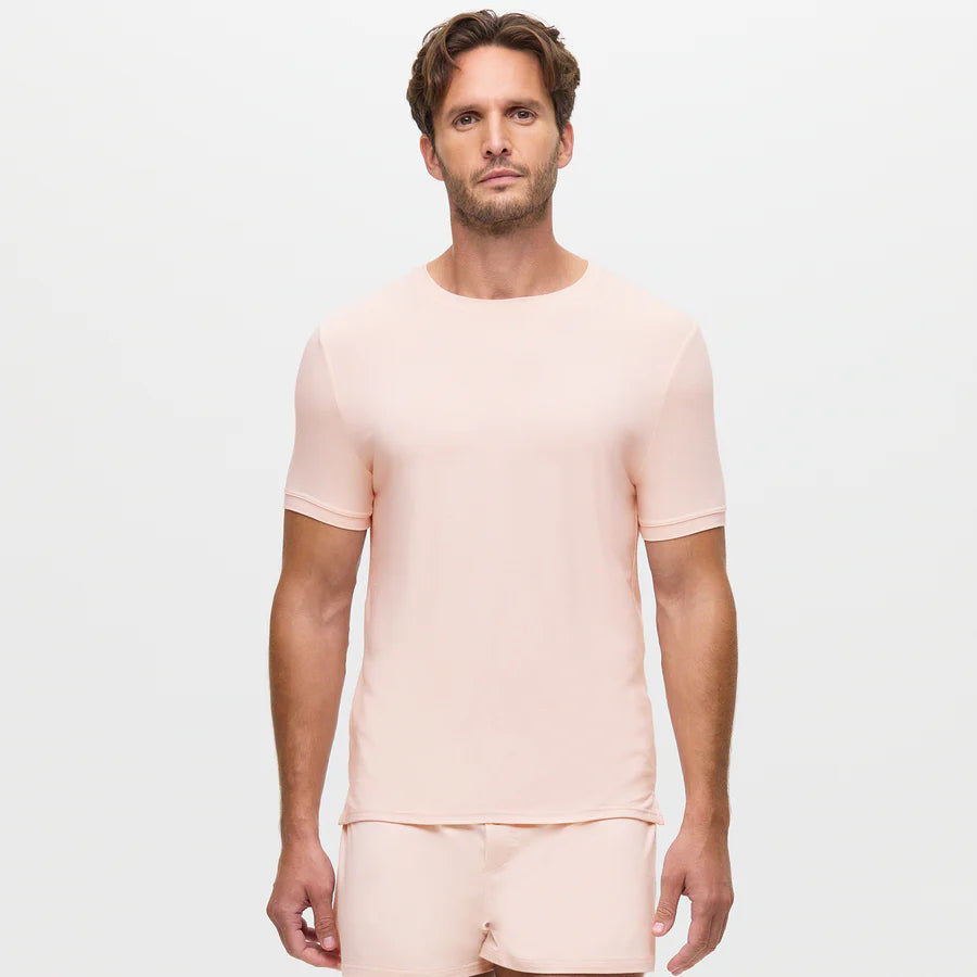 A man with short brown hair and light stubble wears the Homebody Pink Modal Classic Cut T-Shirt, standing against a white background facing the camera with a neutral expression and arms relaxed at his sides. , available at Richard Gelding Mayfair