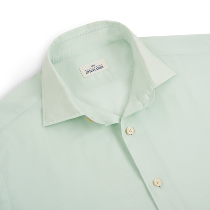 A neatly folded Sage Stretch Cotton Panamino Beach Shirt by Alessandro Gherardi is shown. The light green shirt features a classic collar, two white buttons, and a “GHIRARDI” label inside. The fabric looks smooth and well-pressed. , available at Richard Gelding Mayfair