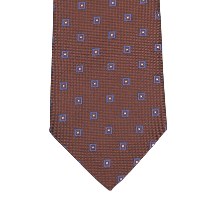 Close-up of Seaward & Stearnâ€™s Cinnamon Brown Geometric Printed Silk Tie, featuring a stunning pattern of blue and orange squares and beautifully crafted by hand.