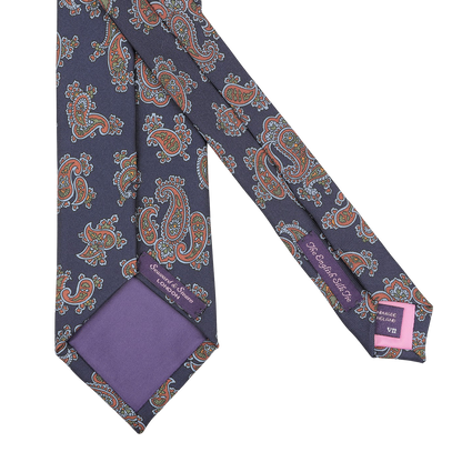 Presenting the Seaward & Stearn Navy Blue Paisley Printed Silk Tie, this exquisite accessory is handmade in England from luxurious silk and features elegant purple accents along with two tags on the back.