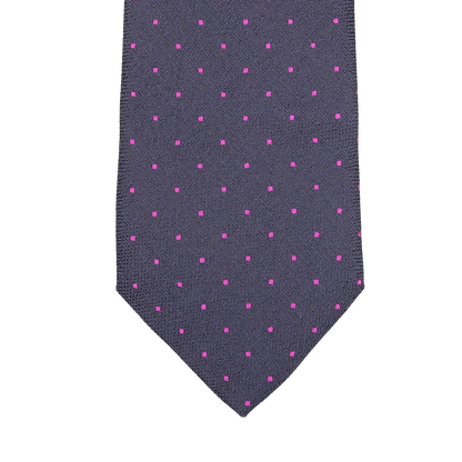 Close-up of a silk tie by Seaward & Stearn in a rich navy blue hue, featuring tiny pink dots woven into an elegant pattern.